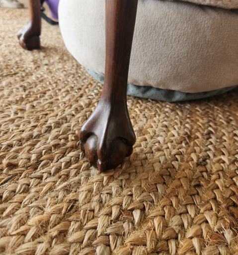 Closeup picture of the feet of a table that were carved in the likeness of duck feet